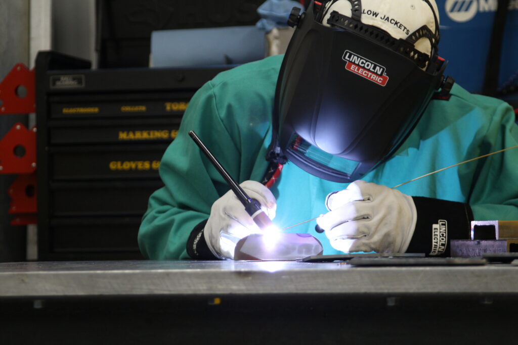Shows a welding master actively welding using our MIG welder.