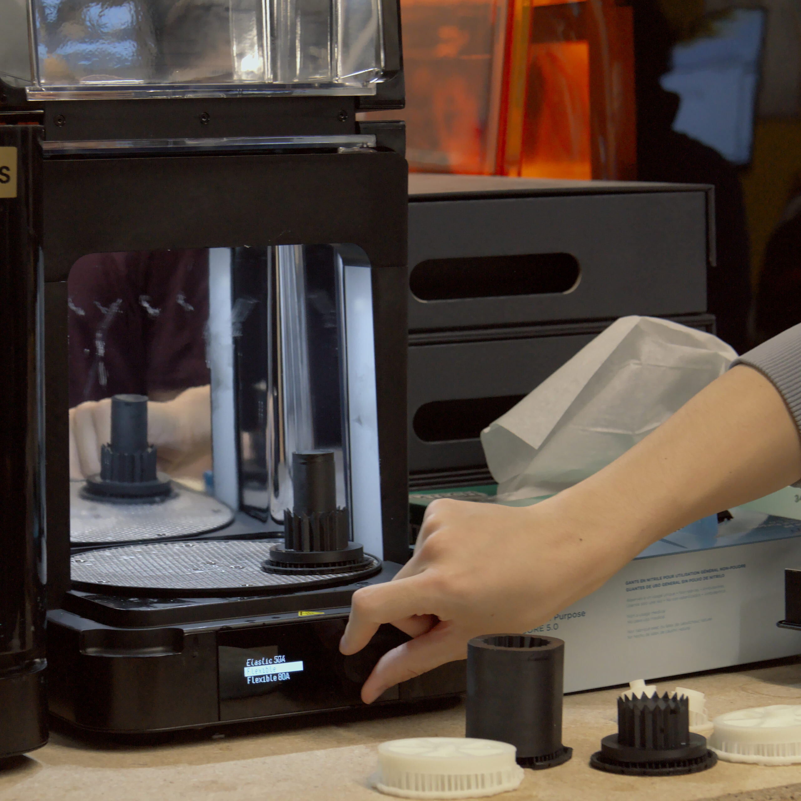 A 3D Printer Master adjusting the setting on a Form Cure with a part inside.